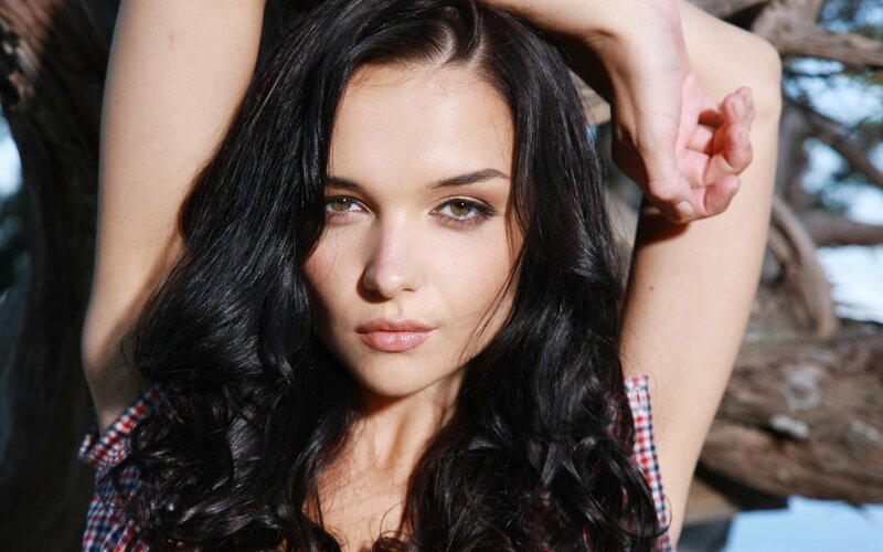 woman with dark hair posing outdoors