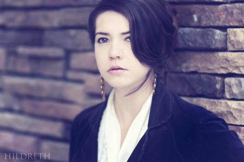Woman with Dark Hair — Purple, Serious, Photograph, Brick Wall