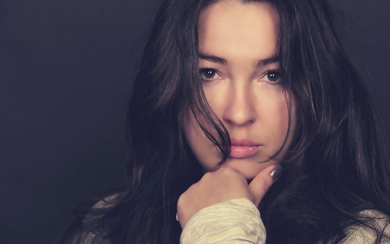 woman with dark hair resting chin