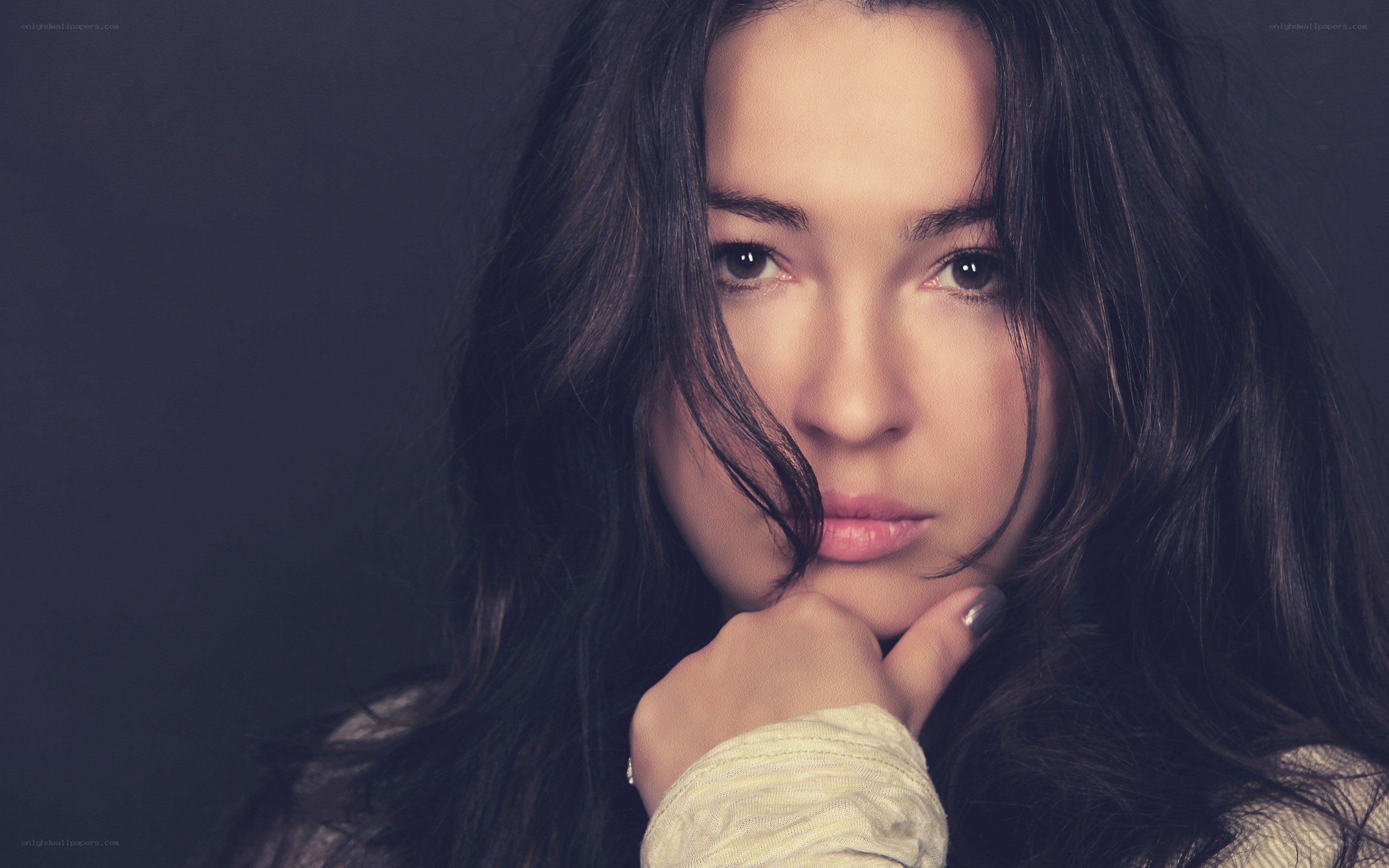 woman with dark hair resting chin