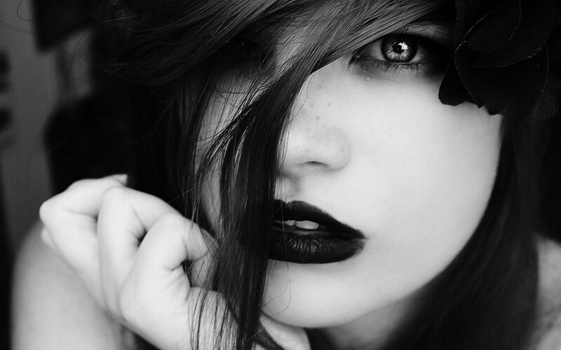woman with dark lipstick and flower