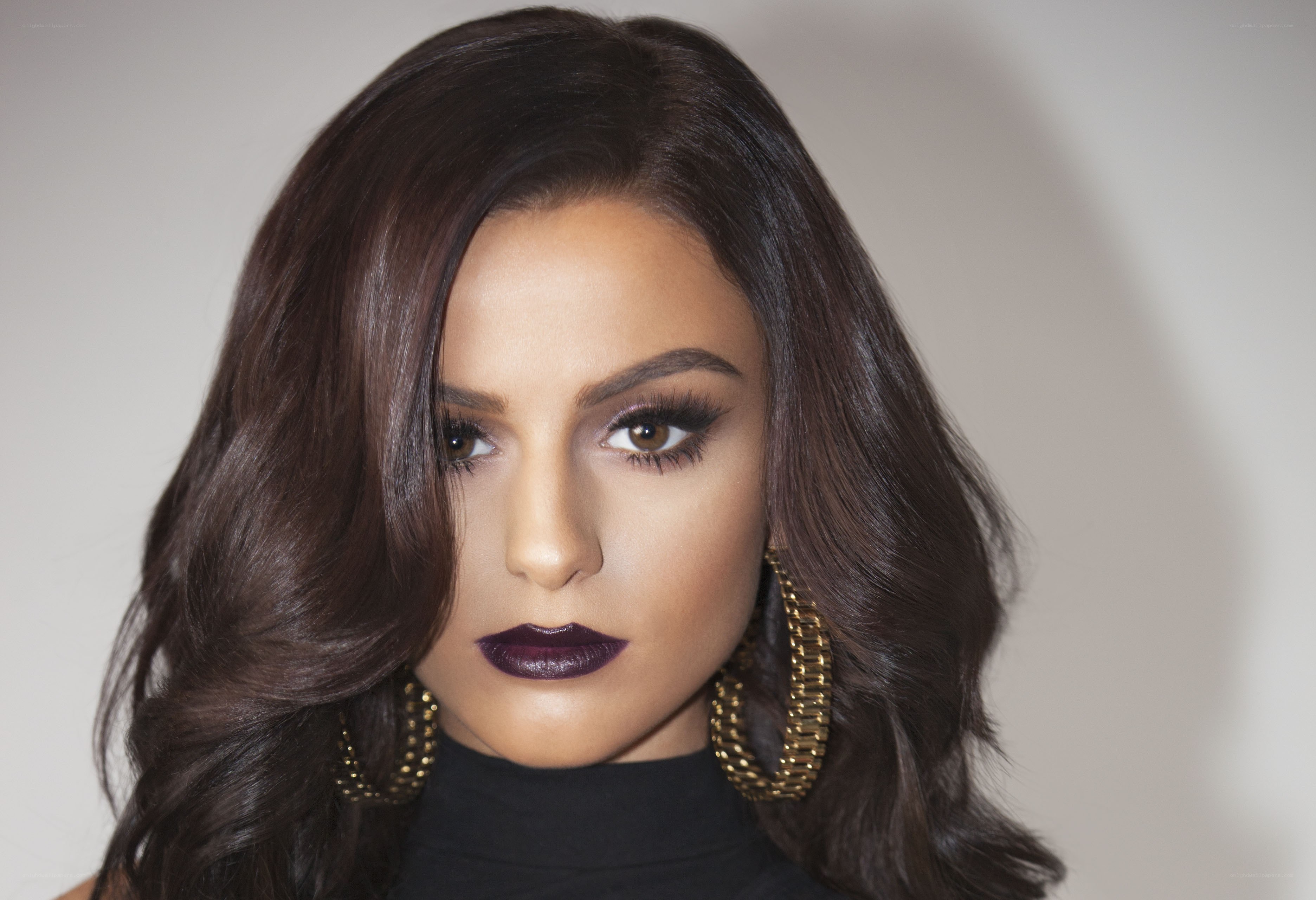 woman with dark lipstick and gold earrings