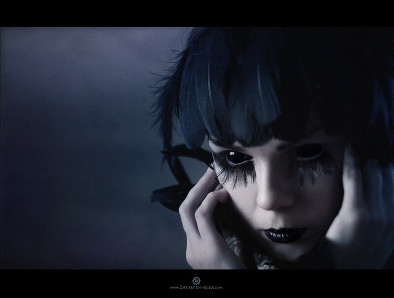 woman with dark makeup and feathers