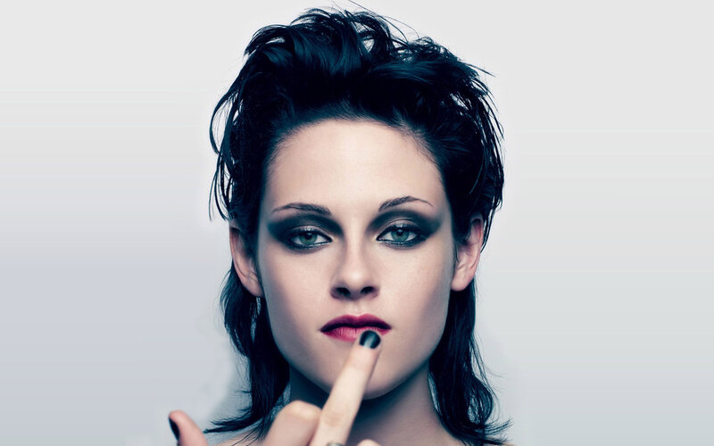 woman with dark makeup and finger to lips