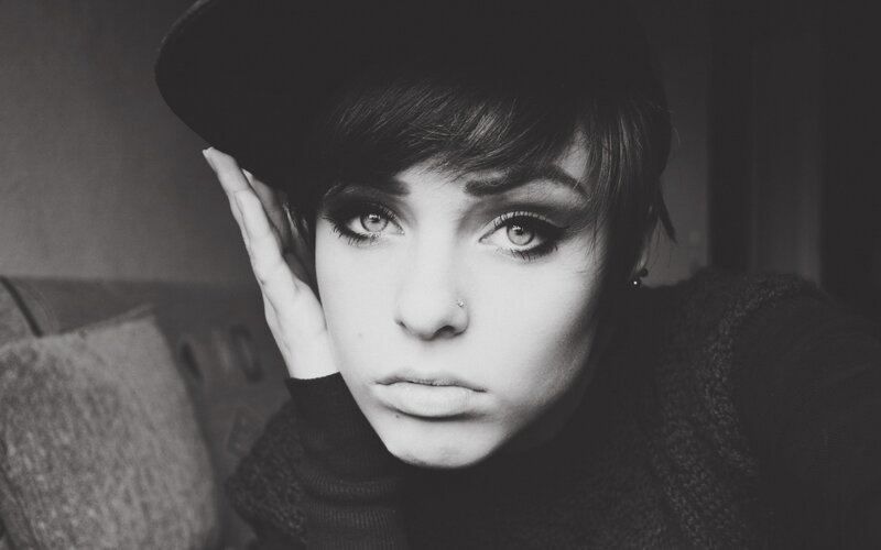 woman with dark makeup and hat