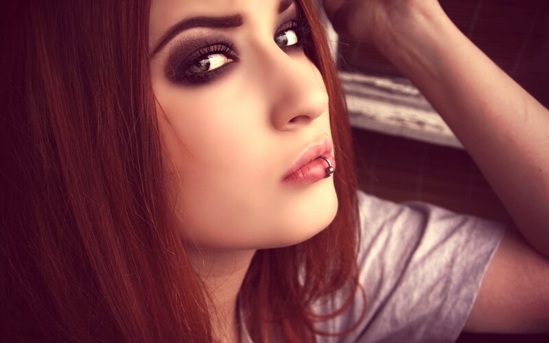 woman with dark makeup and lip piercing