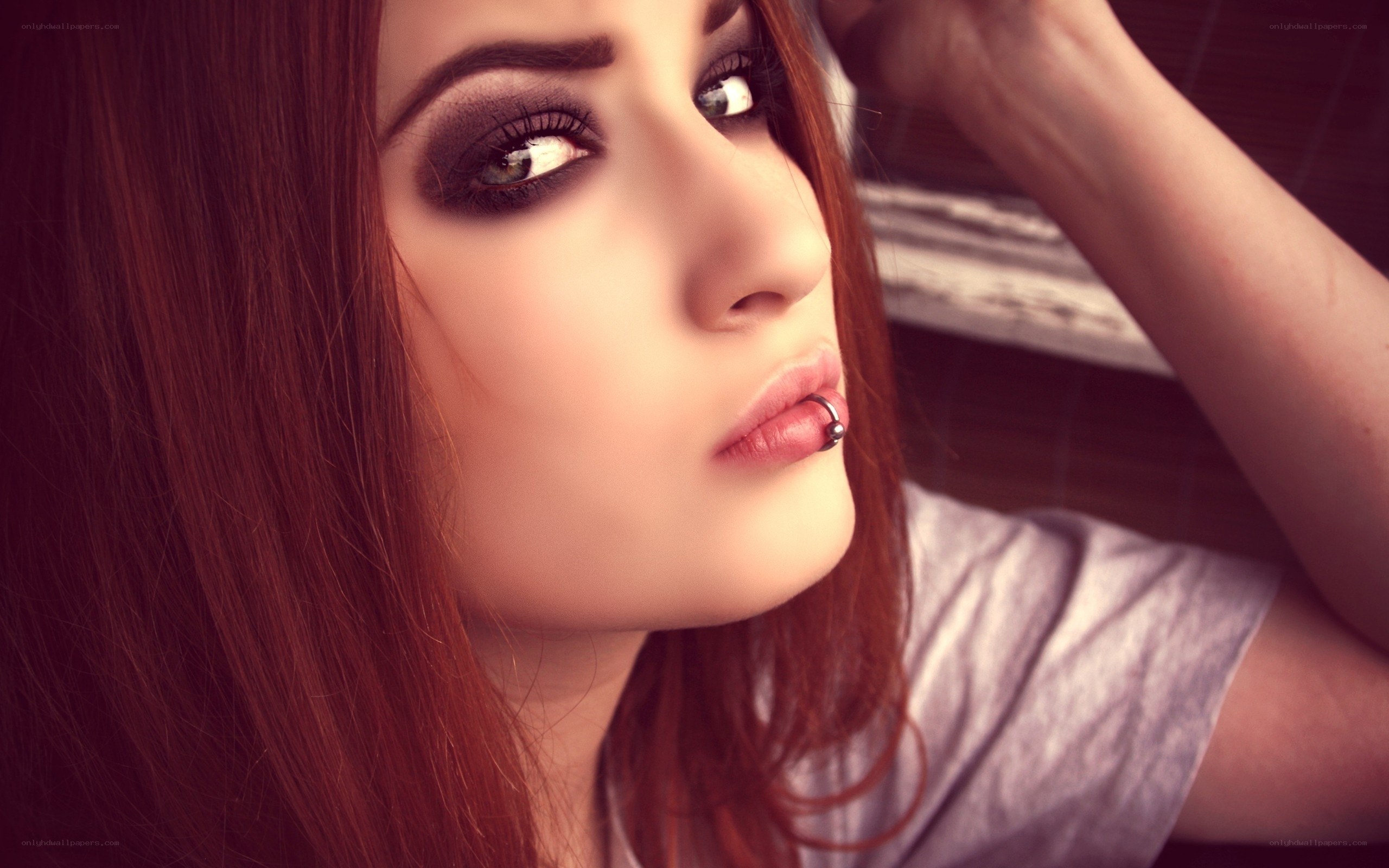 woman with dark makeup and lip piercing