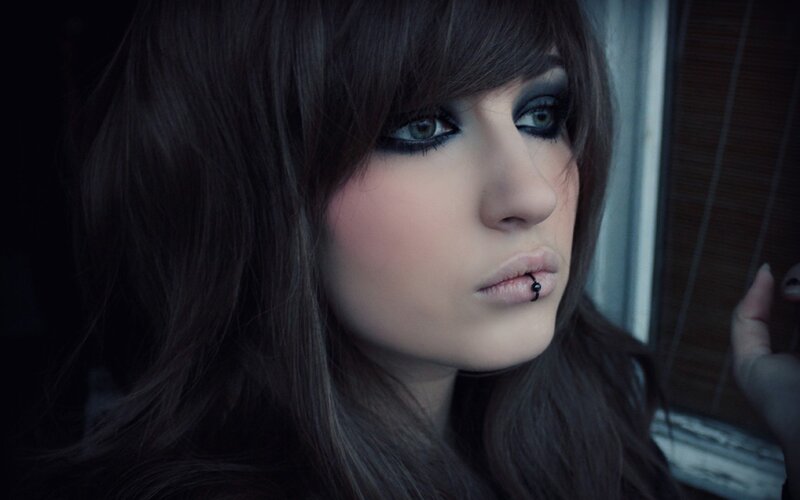 woman with dark makeup and lip piercing