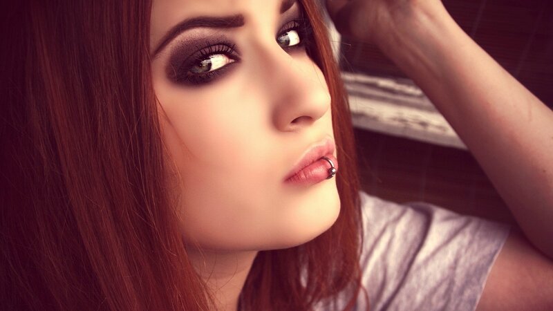 woman with dark makeup and lip piercing