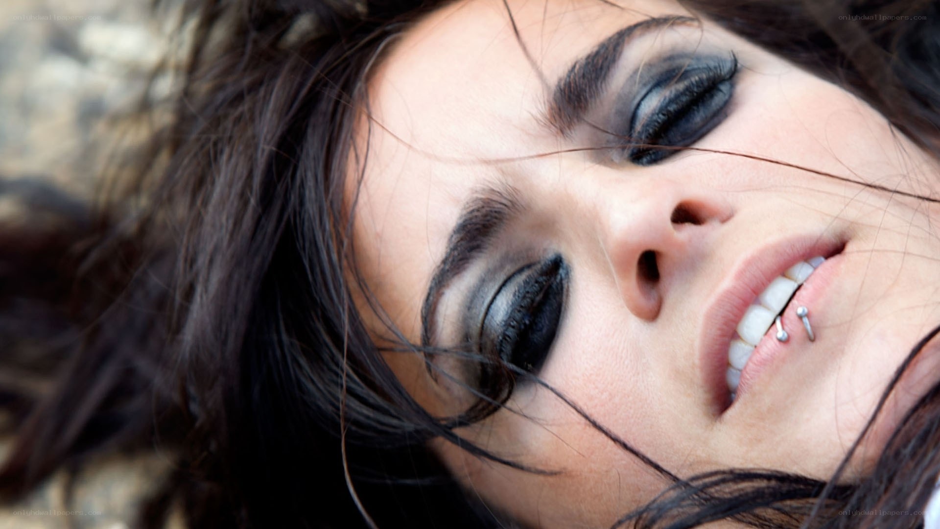 woman with dark makeup and lip piercing