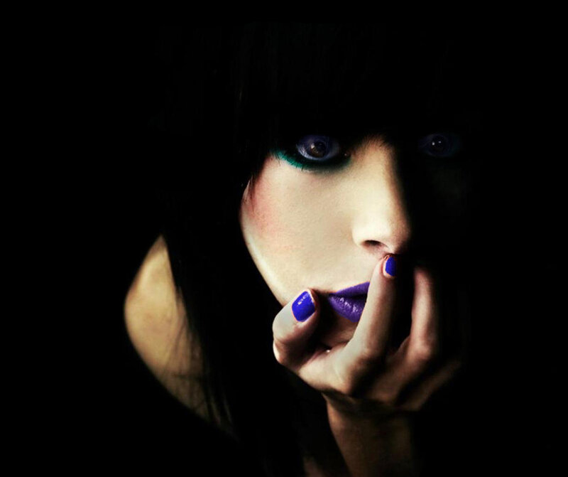 woman with dark makeup and purple nails