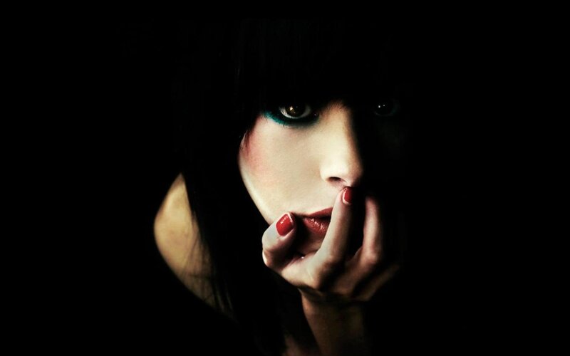 woman with dark makeup and red nails