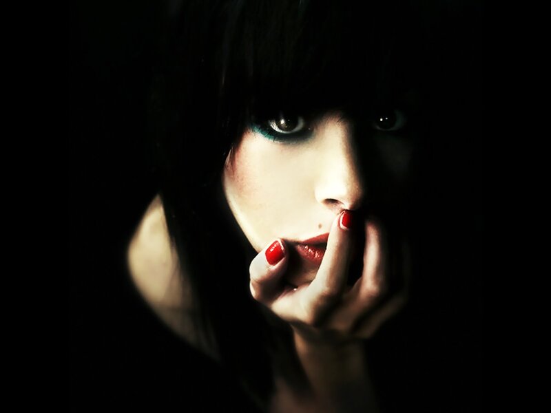 woman with dark makeup and red nails
