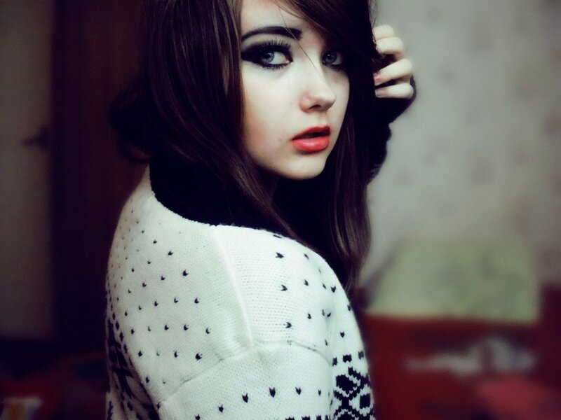 woman with dark makeup and sweater