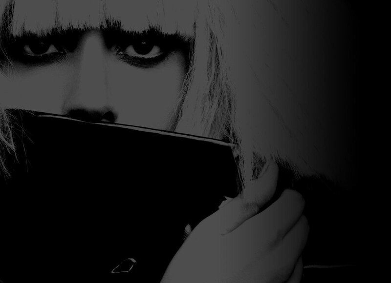 woman with dark makeup holding object