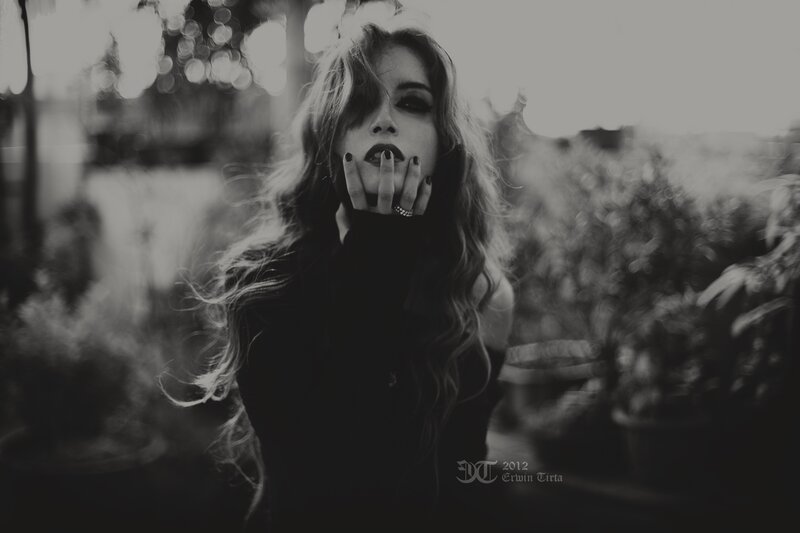 woman with dark makeup in black and white