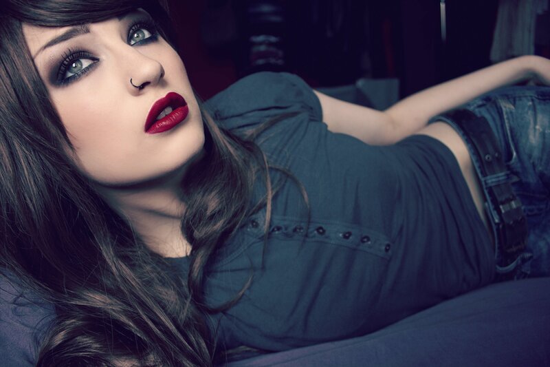 woman with dark makeup lying down