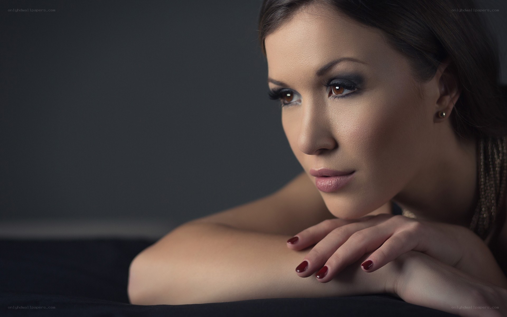 woman with dark makeup resting