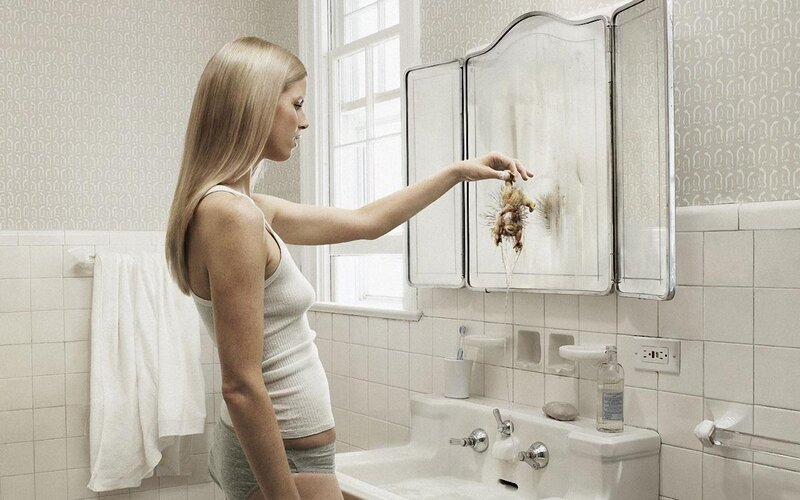 woman with dead bird in bathroom