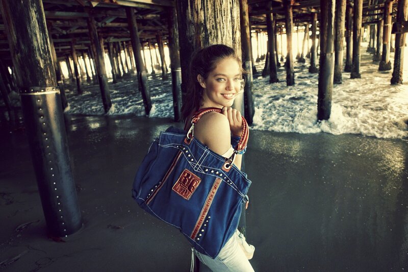 woman with denim bag under pier
