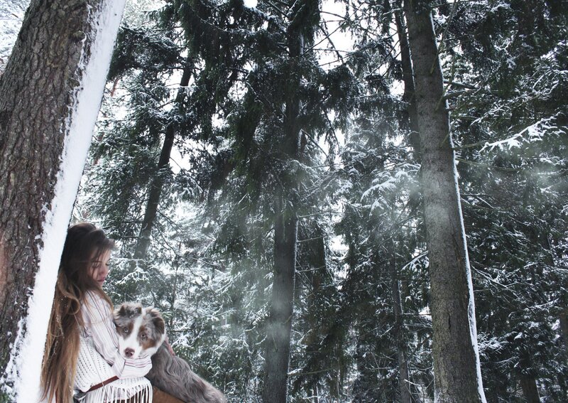 Woman with dog in snowy forest