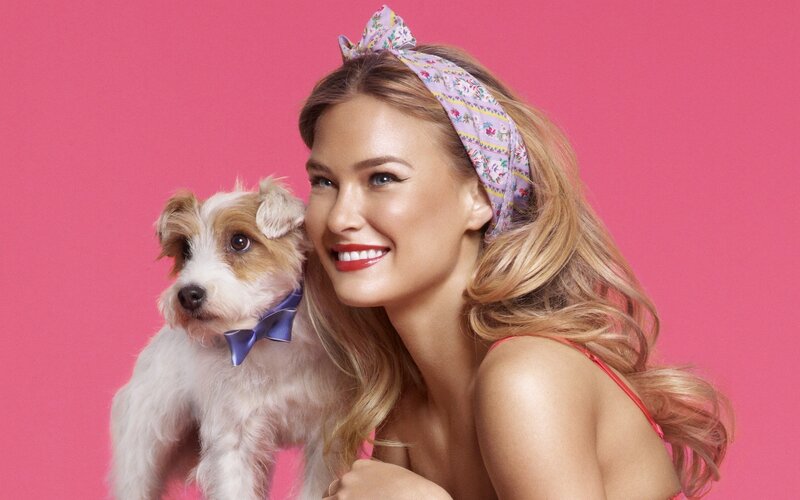 Woman with dog on pink background