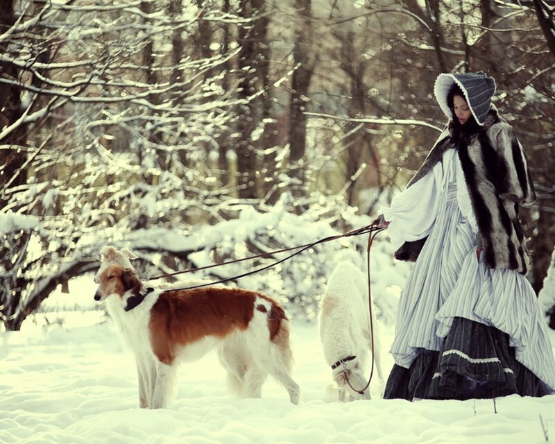 Woman with dogs in snowy forest