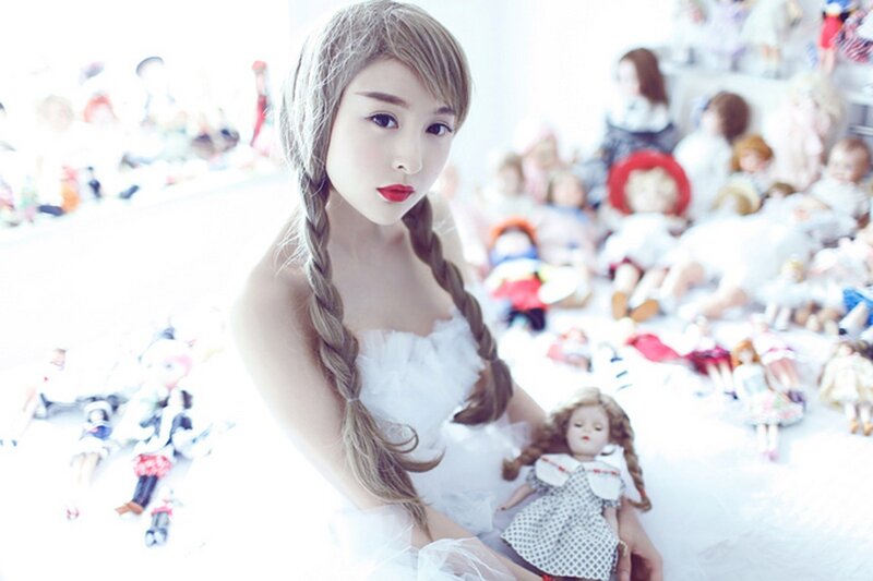 woman with dolls in white room