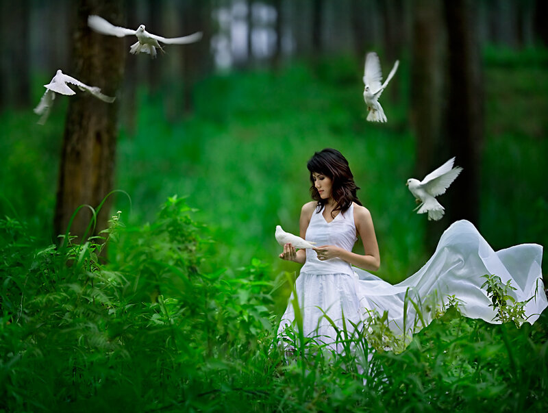 Woman with doves in forest