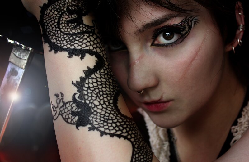woman with dragon tattoo and sword