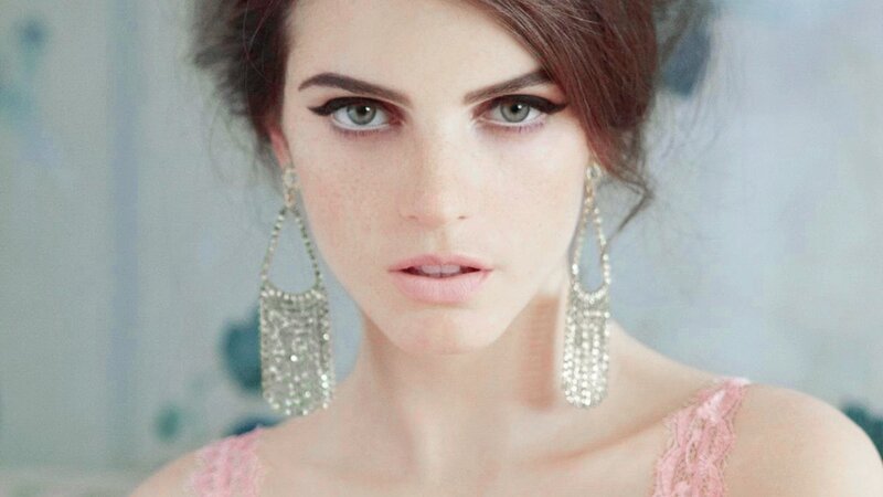 woman with dramatic makeup and earrings