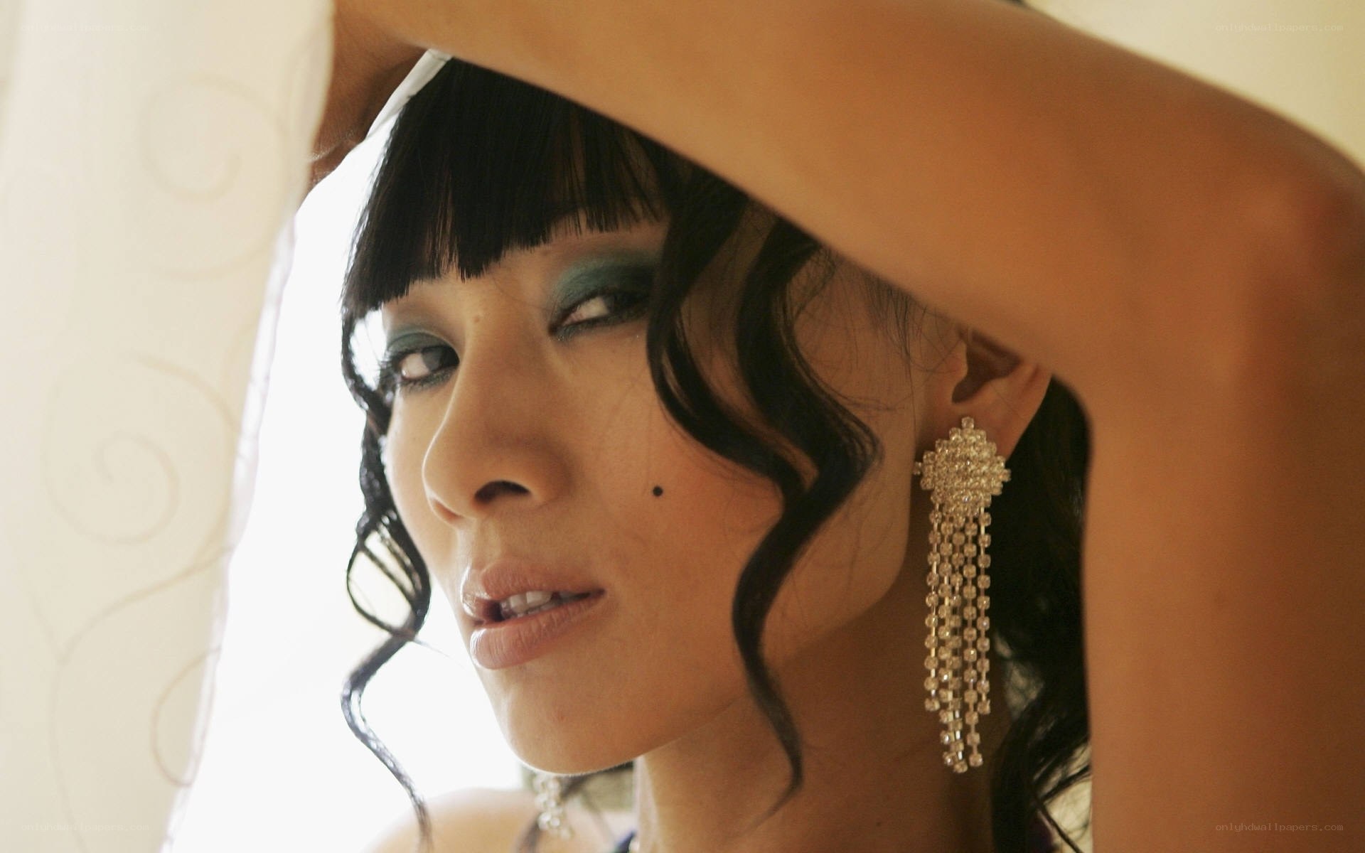 woman with dramatic makeup and earrings