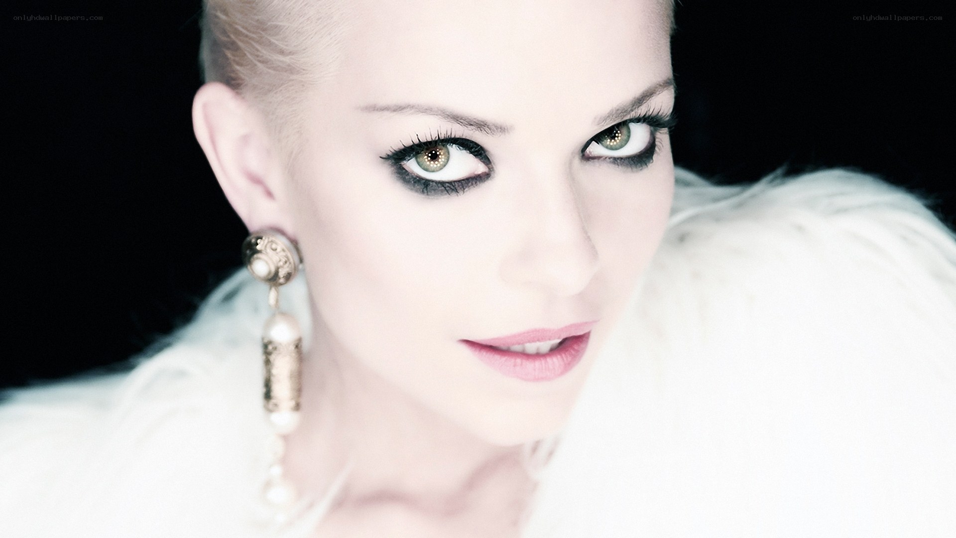 woman with dramatic makeup and earrings