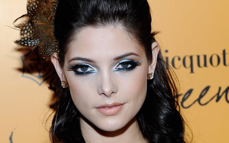 woman with dramatic makeup and feather hair accessory