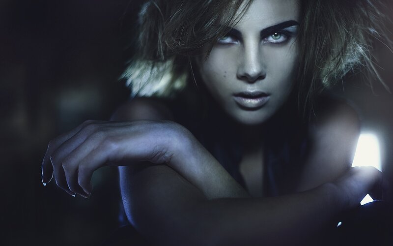 woman with dramatic makeup in dark setting