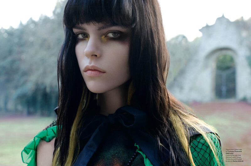 woman with dramatic makeup in green dress