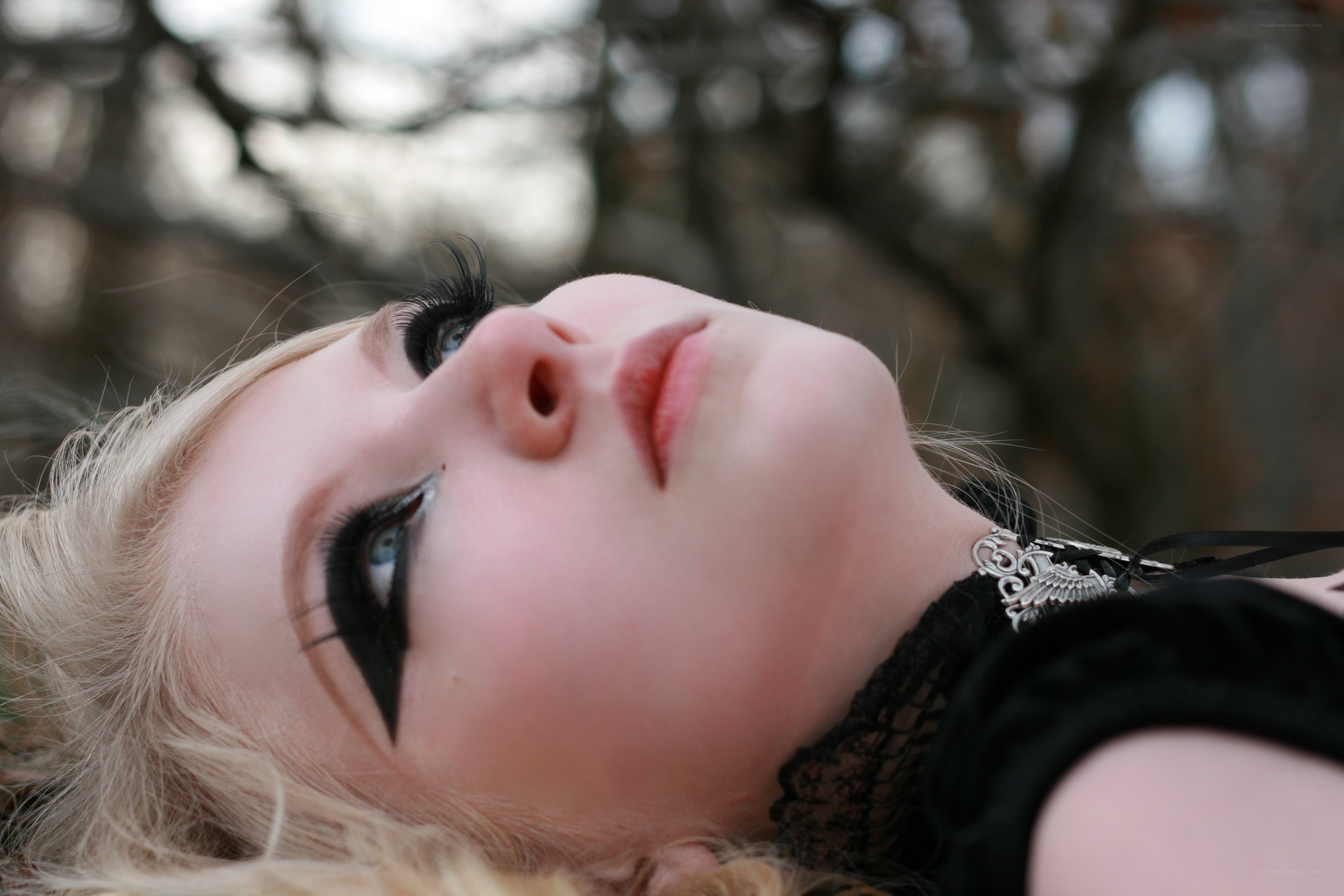 woman with dramatic makeup lying down