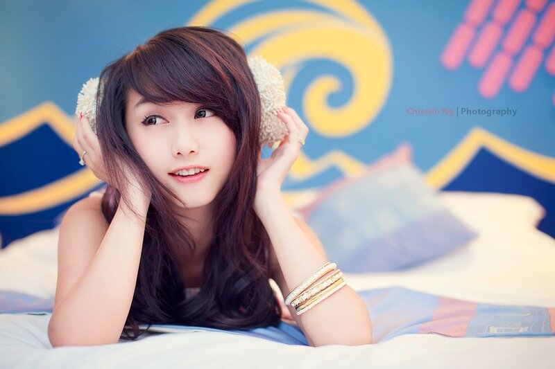 woman with ear muffs on bed