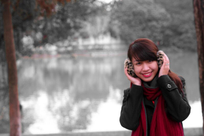 woman with earmuffs by lake