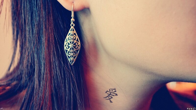woman with earring and tattoo
