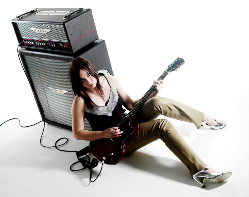 woman with electric guitar and amp