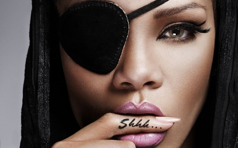 woman with eye patch and finger on lips