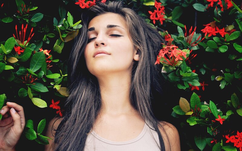 woman with eyes closed among flowers