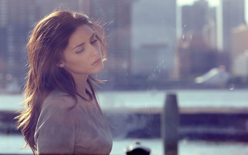 woman with eyes closed by water