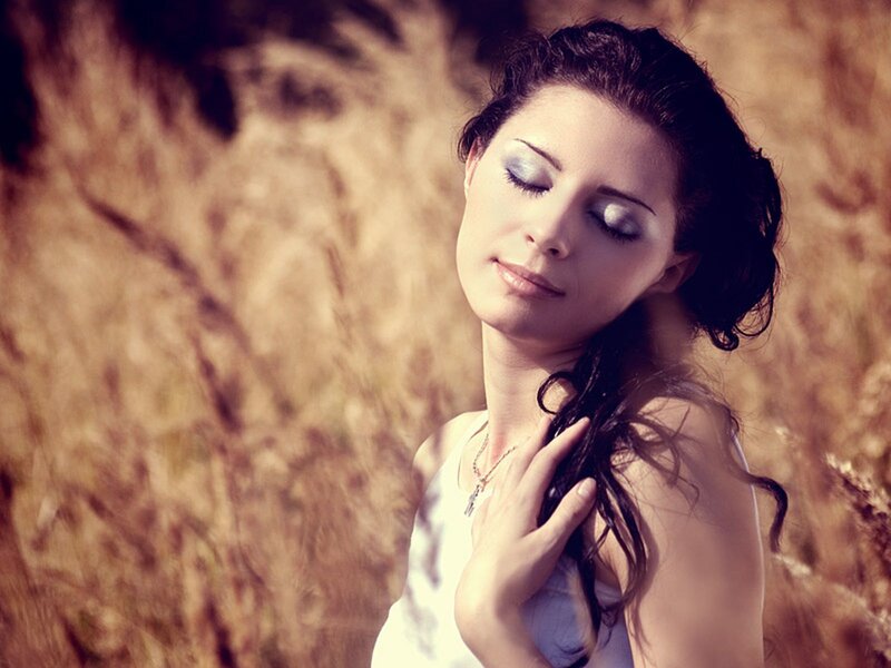 woman with eyes closed in field