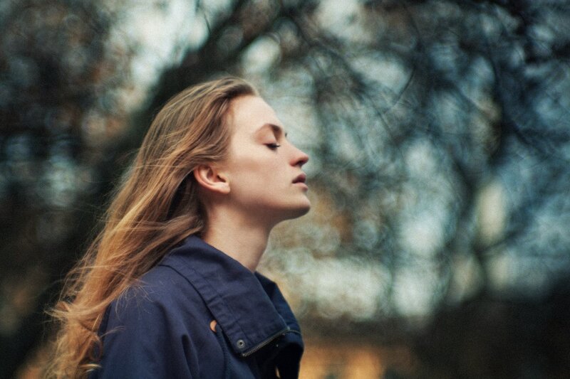 woman with eyes closed outdoors