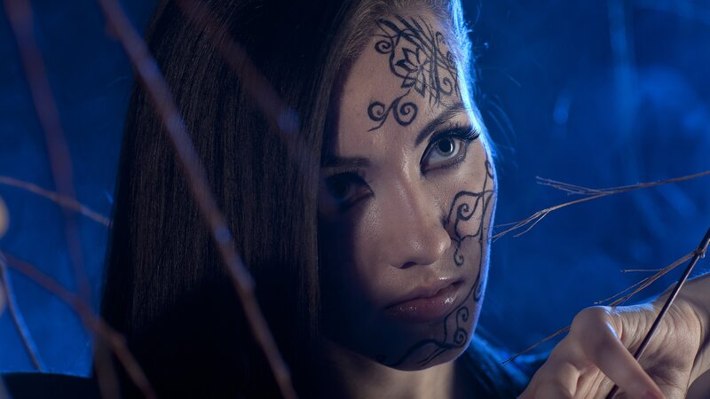 woman with face paint in blue light
