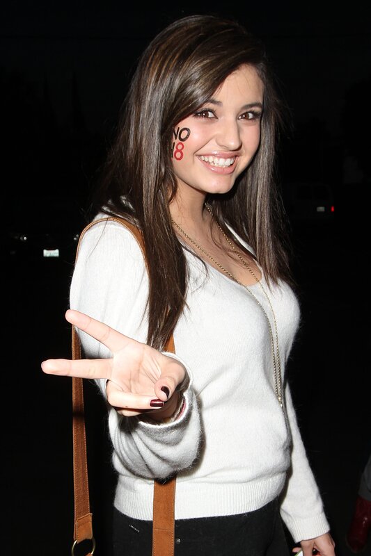 woman with face paint making peace sign