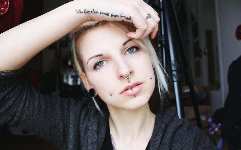 woman with facial piercings and tattoos