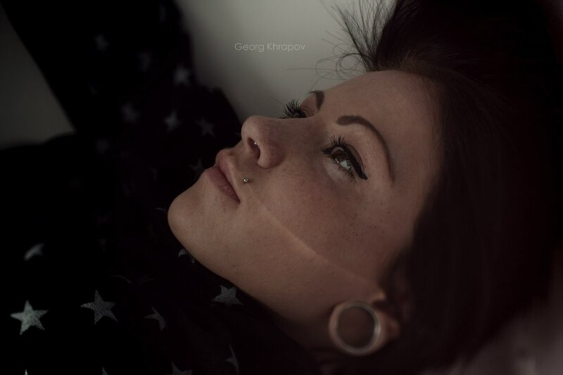 woman with facial piercings lying down